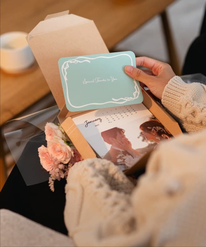 結婚式の写真カレンダーが入ったギフトボックスを開ける様子